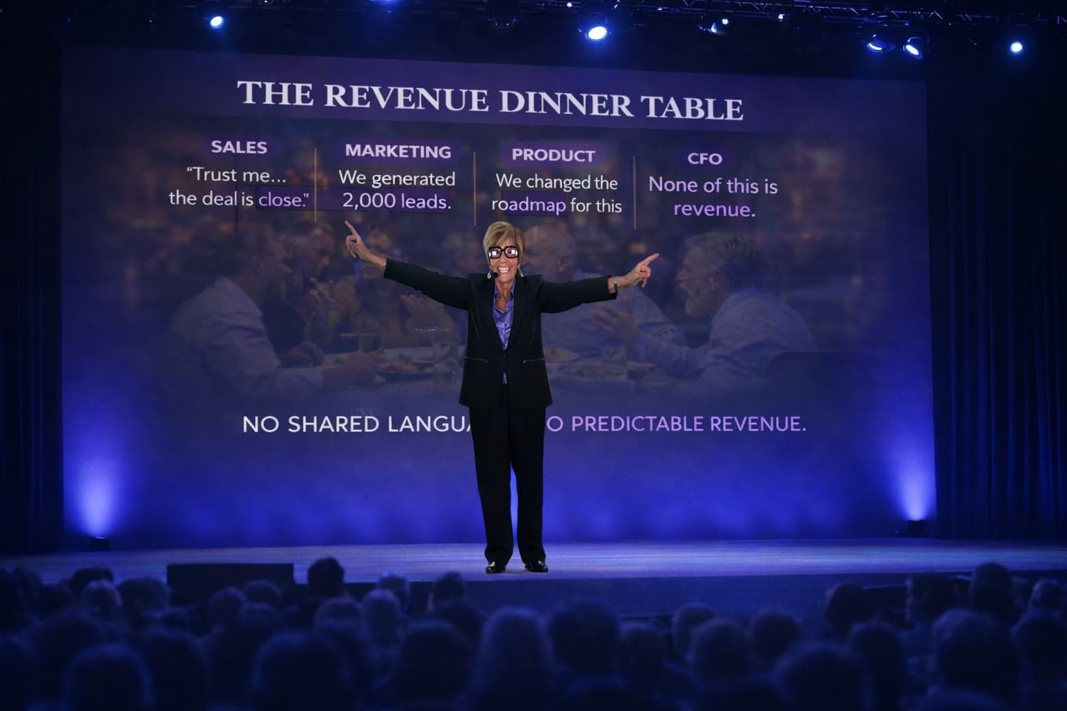Shelley Dunagan speaking on stage in front of the Revenue Dinner Table visual.
